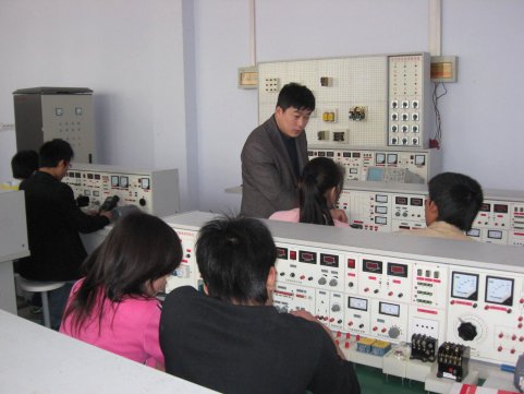 教师在指导学生进行电工实验